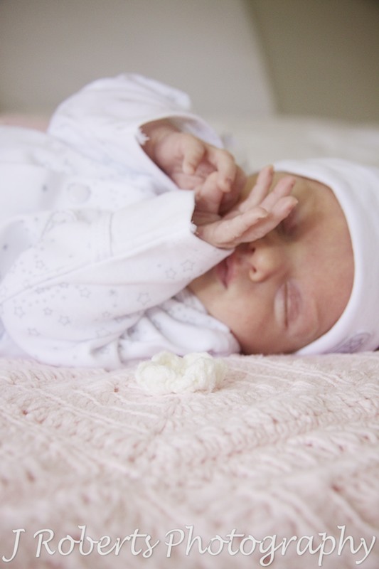 Baby sleeping on pink knitted rug - baby photography sydney